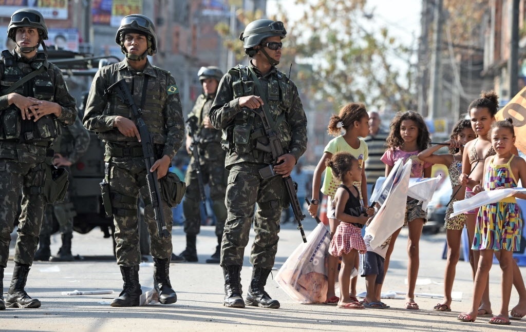 12.set.2014 - Soldados fazem a segurança durante visita da presidente Dilma Rousseff, candidata à reeleição pelo PT, ao Complexo da Maré, no Rio de Janeiro