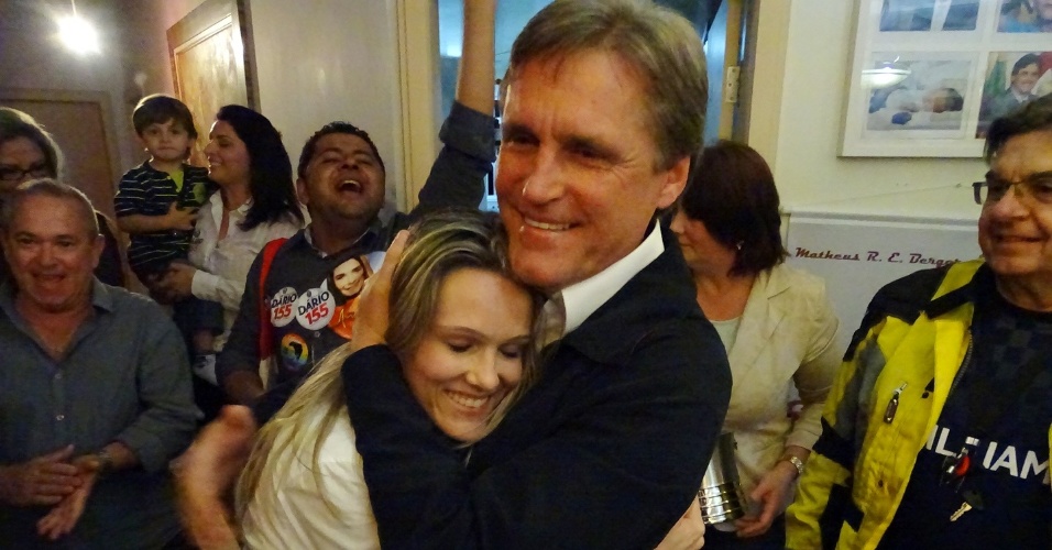 5.out.2014 - O senador eleito por Santa Catarina, Dário Berger (PMDB), recebe abraço enquanto comemora o anúncio da apuração dos votos. Ele venceu o pleito com 42,82% dos votos válidos