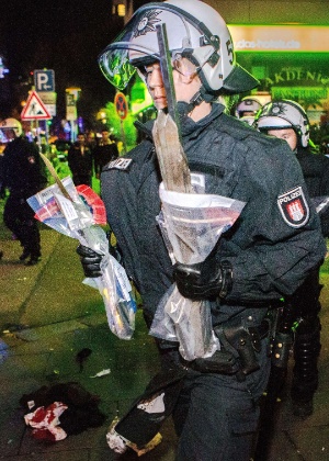 Policial carrega barras encontradas após protesto contra o Estado Islâmico em Hamburgo, na Alemanha