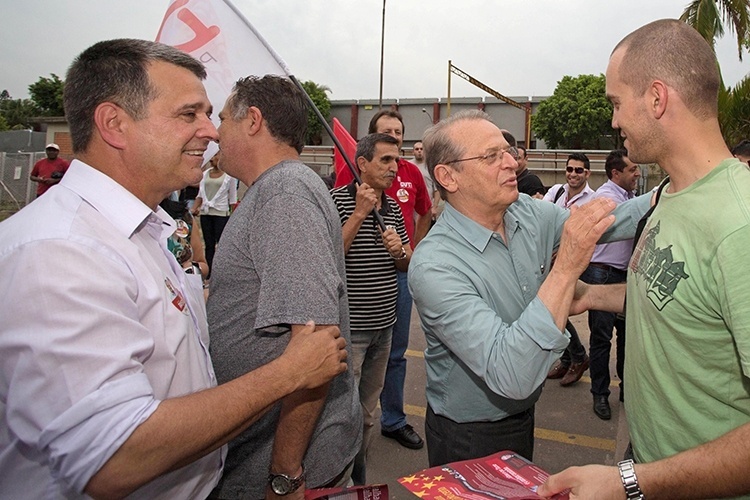 9.out.2014 - O governador e candidato à reeleição, Tarso Genro, conversa com trabalhadores durante caminhada na cidade de Canoas