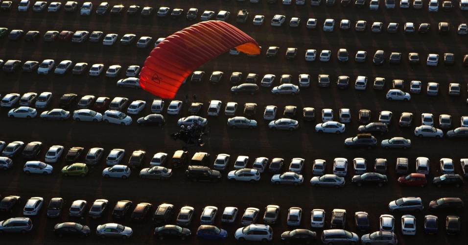 14.out.2014 - Um parapente com motor sobrevoa um estacionamento durante um festival internacional de balão de ar quente no vale de Jezreel, em Israel