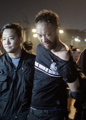 Vestido com uma camisa do Corinthians, Ken Tsang, membro do Partido Cívico, é levado por policiais de Hong Kong após confronto