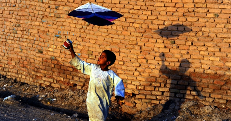 21.out.2014 - Criança brinca com uma pipa nos arredores da cidade de Herat, no Afeganistão