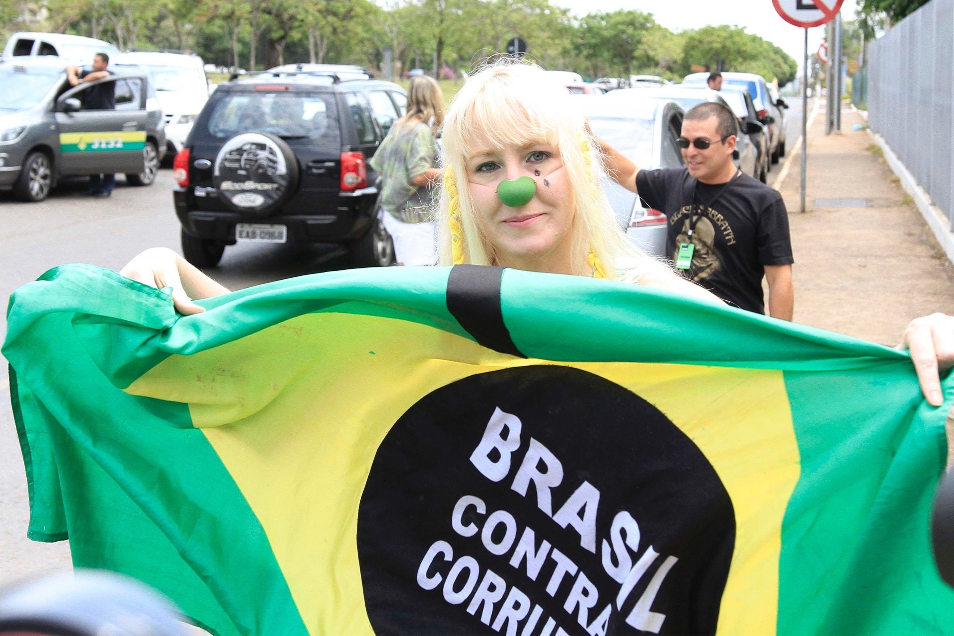 26.out.2014 - Eleitora protesta contra corrupção em frente à escola em Brasília, no Distrito Federal, neste domingo (26)