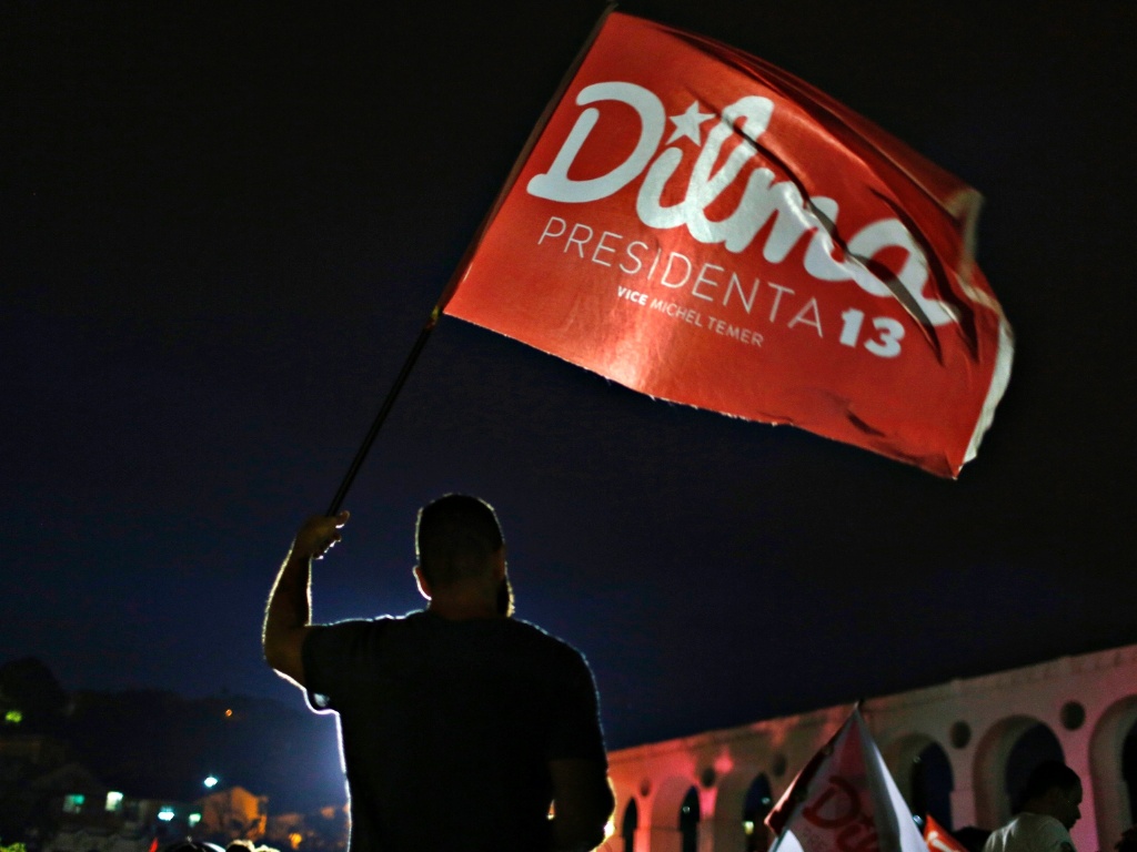 26.out.2014 - Partidário da presidente reeleita Dilma Rousseff (PT) segura uma bandeira antes de saber o resultados das eleições presidenciais, neste domingo (26), no Rio de Janeiro. Dilma Rousseff foi reeleita