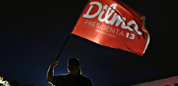 Partidário da presidente reeleita Dilma Rousseff (PT) segura uma bandeira antes de saber o resultados das eleições presidenciais, no Rio de Janeiro, em 26 de outubro de 2014 - Pilar Olivares/Reuters