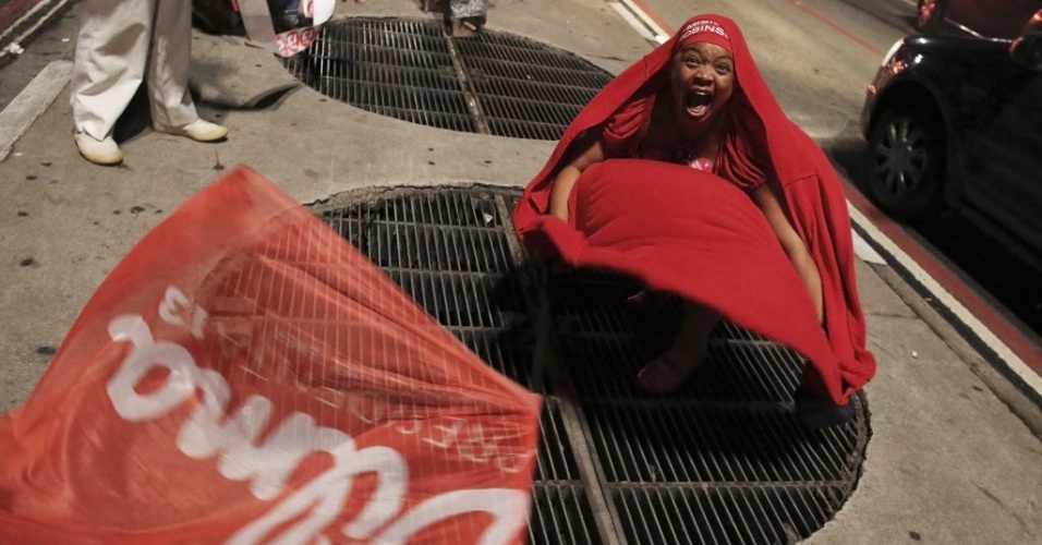 26.out.2014 - Uma militante grita após saber o resultado do segundo turno das eleições, que deu vitória para a presidente Dilma Rousseff (PT), durante ato na avenida Paulista, na região central de São Paulo, neste domingo (26)