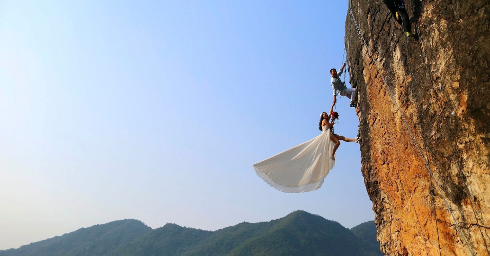 27.out.2014 - Casal de alpinistas amadores tira fotos do casamento em um penhasco em Jinhua, na província de Zhejiang, na China