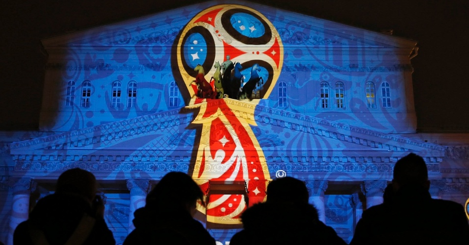29.out.2014 - Pessoas observam instalação de luz com o logotipo oficial da Copa do Mundo da FIFA 2018, durante a cerimônia de inauguração no prédio do Teatro Bolshoi, em Moscou, na Rússia