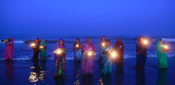  Devotas hindus oram em pé nas águas do Mar Arábico, em adoração ao deus sol Surya durante o festival religioso "Chatt Puja", em Mumbai, na Índia - Danish Siddiqui/Reuters