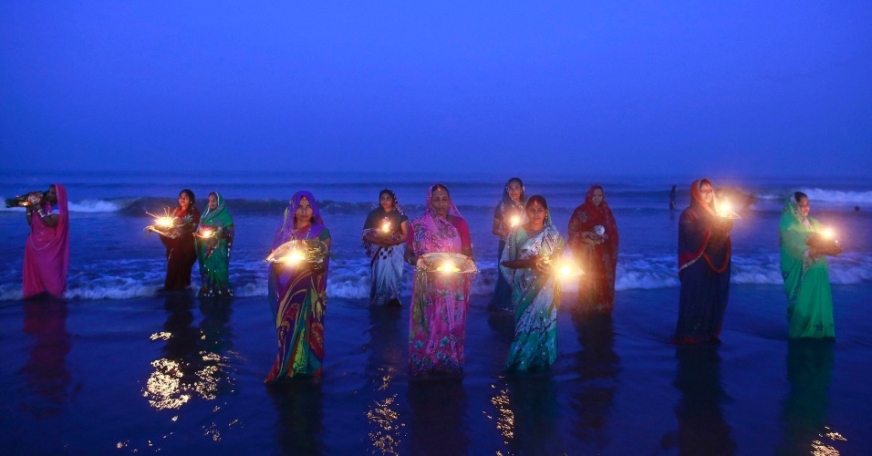 30.out.2014 - Devotas hindus oram em pé nas águas do Mar Arábico, em adoração ao deus sol Surya durante o festival religioso "Chatt Puja", em Mumbai, na Índia