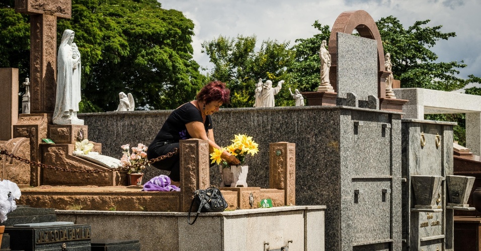 Mulher leva flores a túmulo no cemitério da Saudade, no interior paulista - Igor do Vale/Futura Press/Estadão Conteúdo 