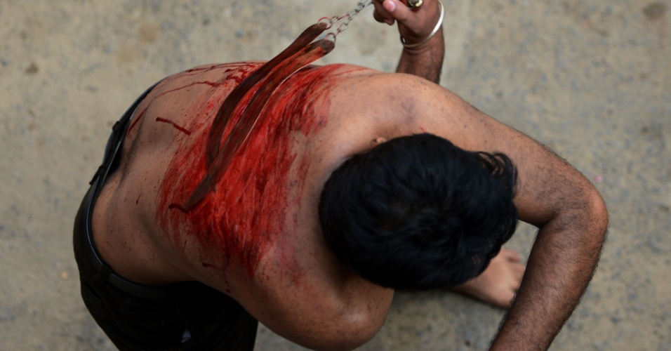 1º.nov.2014 - Devoto muçulmano participa de ritual de autoflagelação em uma procissão em Ahmedabad, na Índia