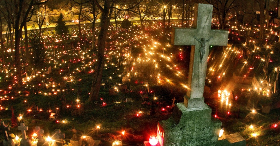 1º.nov.2014 - Velas são acessas nos túmulos de um cemitério em Vilnius, na Lituânia, em celebração ao Dia de Finados