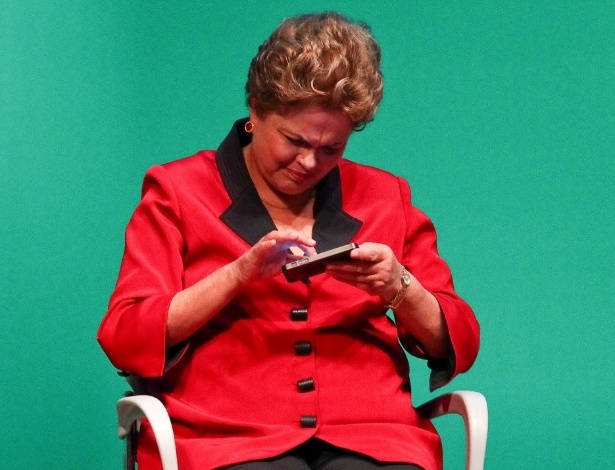 A presidente Dilma Rousseff mexe no telefone do ministro Afif Domingos (Micro e Pequena Empresa), durante evento em 2014 - Pedro Ladeira/Folhapress