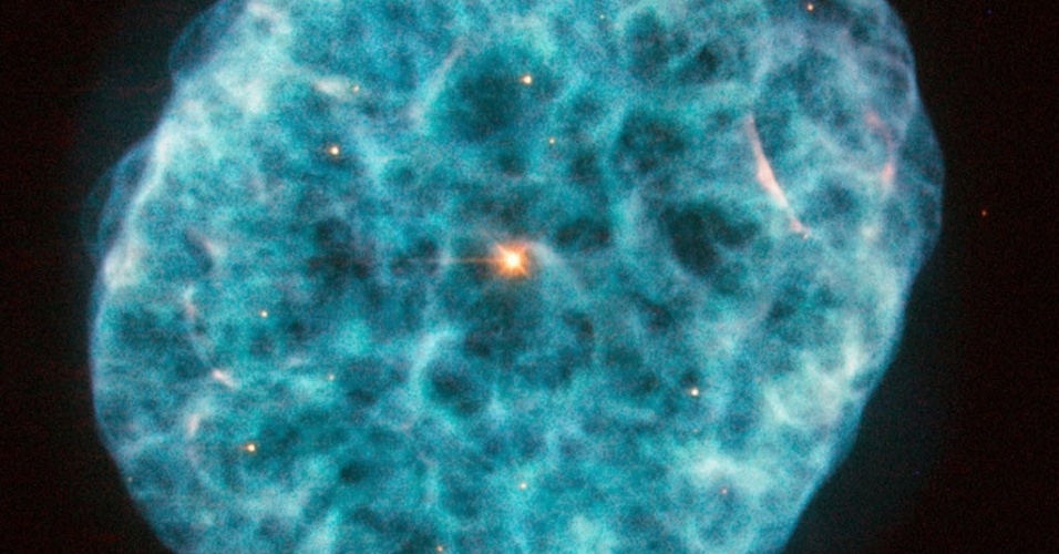 13.nov.2014 - Imagem obtida pelo telescópio Hubble, da Nasa (agência espacial americana), mostra a nebulosa NGC 1501,também conhecida como nebulosa da ostra, localizada na constelação da Girafa. Com nuvens irregulares e repleta de regiões acidentadas, a nebulosa possui uma estrela central brilhante, que pode ser visto facilmente nesta imagem. Ainda que estrelas variáveis não sejam incomuns, é raro encontrar uma no coração de uma nebulosa planetária. Descoberta por William Herschel em 1787, NGC 1501 é uma nebulosa planetária que está a pouco menos de 5.000 anos-luz de distância