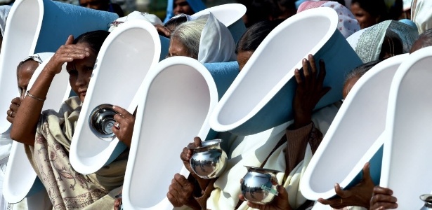 18.nov.2014 - Mulheres carregam vasos sanitários em suas cabeças na abertura do Festival Internacional do Banheiro, em Nova Délhi - Roberto Schimidt/ AFP