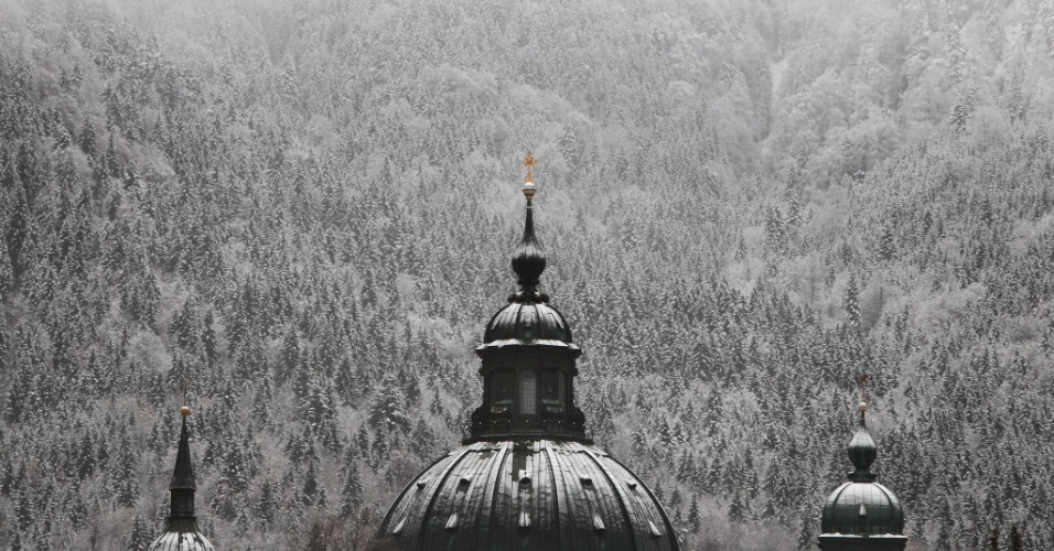 18.nov.2014 - Torre da abadia de Ettal aparece coberta de neve em frente de paisagem em Ettal, na Alemanha