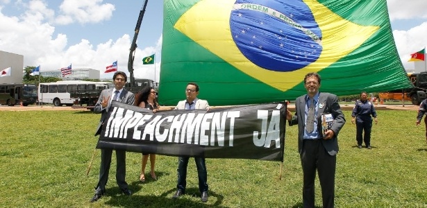 19.nov.2014 - Manifestantes protestaram nesta quarta-feira (19) pelo impeachment da presidente Dilma Rousseff durante cerimônia para comemorar o dia da Bandeira, realizada no gramado em frente ao Congresso Nacional, em Brasília, com uma bandeira nacional gigante - Alan Marques/ Folhapress
