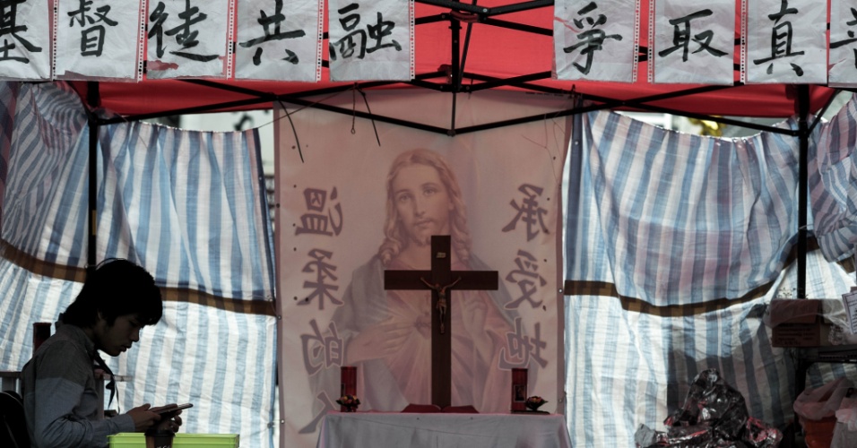 19.nov.2014 - Um manifestante pró-democracia rza em capela improvisada no bairro Mongkok, em Hong Kong, na China