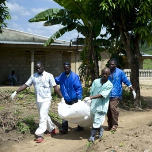 21.nov.2014 - Trabalhadores da Cruz Vermelha carregam o corpo de uma vítima de ebola em Patrice, perto de Macenta, na Guiné - Kenzo Tribouillard/AFP