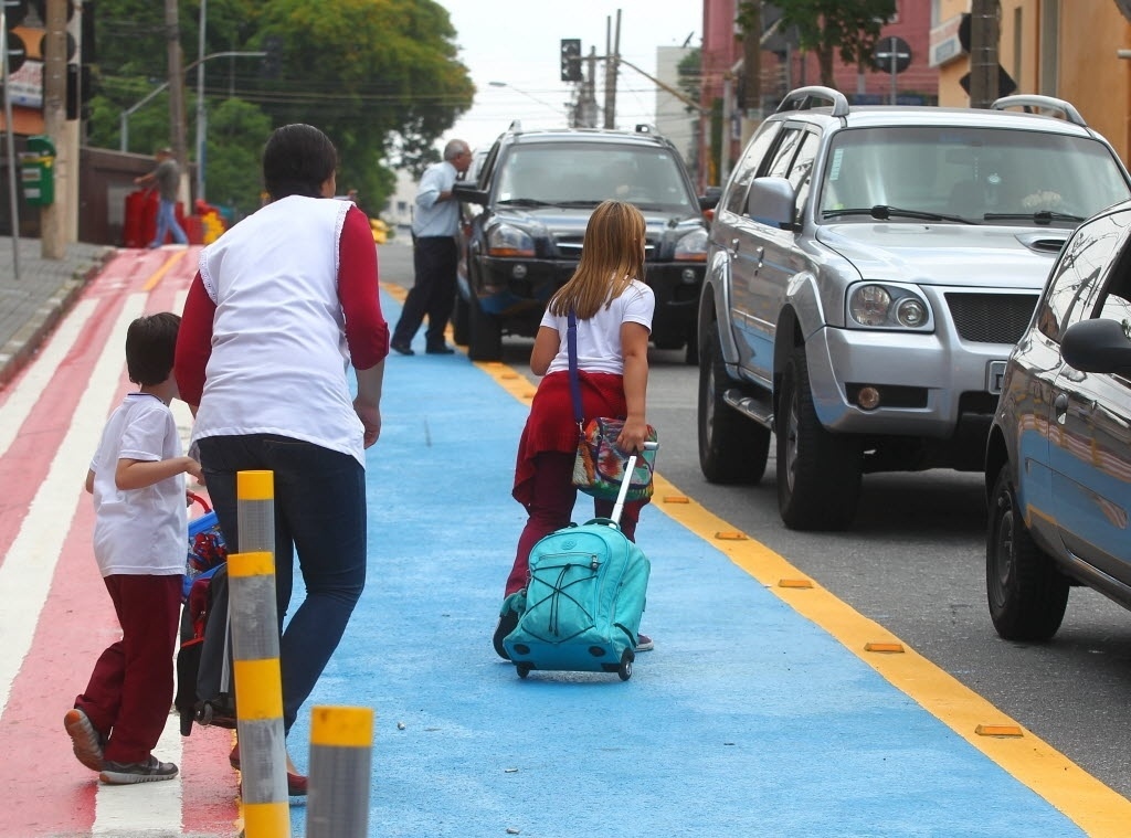 25.nov.2014 - A faixa vermelha, para bicicletas, ganhou uma colega azul em uma rua da Vila Mariana, zona sul de São Paulo, no dia 17 de novembro. A pista azul é parte de um projeto piloto da CET (Companhia de Engenharia e Tráfego) para que alunos do colégio Madre Cabrini possam embarcar e desembarcar dos carros. Mas pais e funcionários não aprovaram e fizeram até um abaixo-assinado contra a novidade. Dizem que a prefeitura expõe as crianças ao risco de atropelamento pelas bicicletas e dificulta a passagem dos veículos - Vinicius Pereira/ /Folhapress