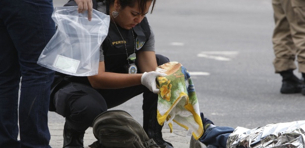 Policiais identificam e recolhem uma vasilha que pertencia a Elivaldo Angelino Ribeiro, 44, que morreu após ser atingido por uma bala perdida no centro do Rio - Severino Silva/Agência O Dia/Estadão Conteúdo 