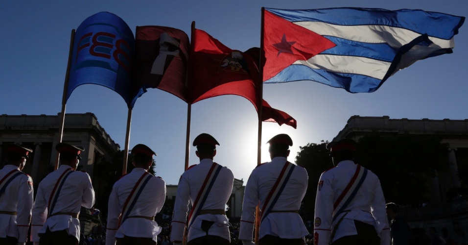 28.nov.2014 - Soldados seguram bandeira nacional e da Liga da Juventude Comunista, durante uma cerimônia em Havana, em Cuba