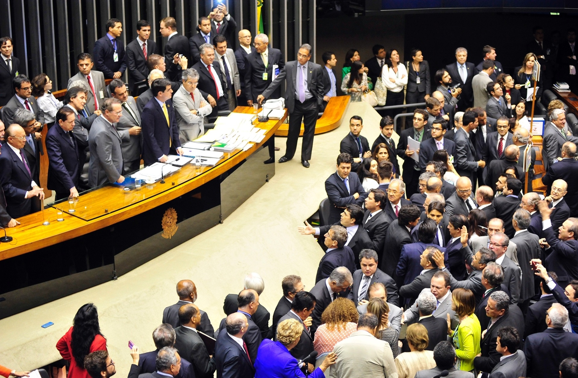 2.dez.2014 - A sessão do Congresso Nacional para votar a manobra fiscal a que o governo recorreu para tentar fechar as contas de 2014 foi marcada pela troca de socos, empurra-empurra e muita gritaria. Após a interrupção de manifestantes, que gritavam "PT roubou" e "vá para Cuba", o presidente do Congresso, senador Renan Calheiros (PMDB-AL), mandou esvaziar as galerias do plenário, mas congressistas da oposição fizeram um cordão de isolamento para tentar impedir ação da Polícia Legislativa. A votação foi suspensa - Gustavo Lima / Câmara dos Deputados