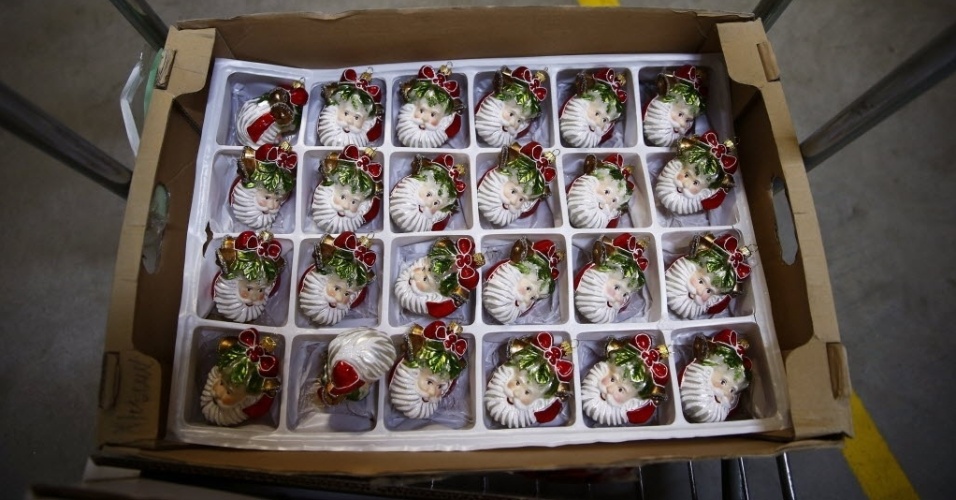2.dez.2014 - Enfeites com formato de Papai Noel são transportados para serem colocados à venda em uma fábrica de enfeites natalinos feitos a mão, na cidade de Jozefow, perto de Varsóvia, na Polônia