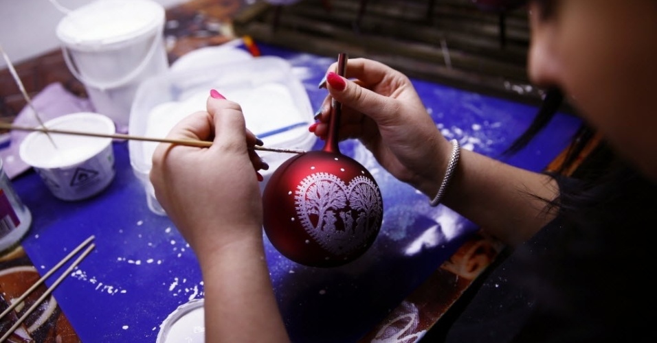 2.dez.2014 - Funcionário faz pintura em bola de vidro para enfeitar árvores de Natal em uma fábrica de enfeites natalinos feitos a mão, na cidade de Jozefow, perto de Varsóvia, na Polônia