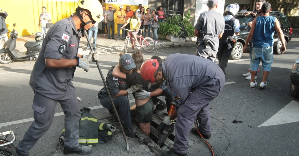 3.dez.2014 - Agentes do Corpo de Bombeiros trabalham no resgate de uma mulher que caiu em um bueiro na avenida Nossa Senhora do Carmo com a Rua Montes Claros, no centro de Belo Horizonte (MG), nesta quarta-feira (3)