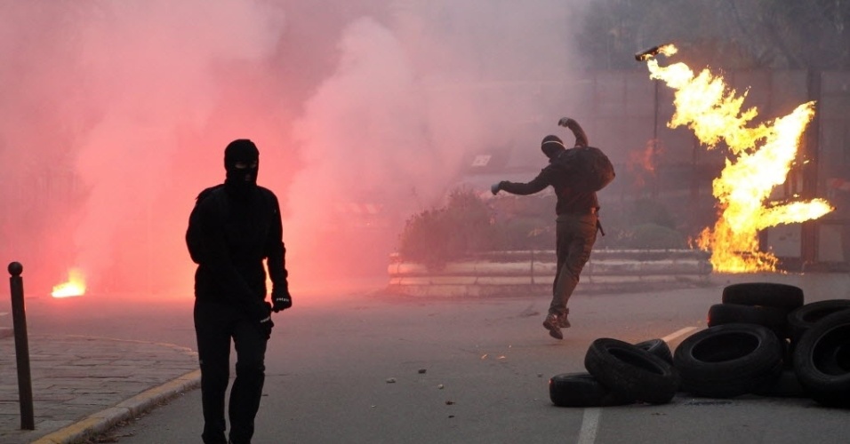 3.dez.2014 - Manifestante nacionalista lança um coquetel molotov contra policiais durante um protesto contra o governo na cidade francesa de Corte, em Alta Córsega, nesta quarta-feira (3)