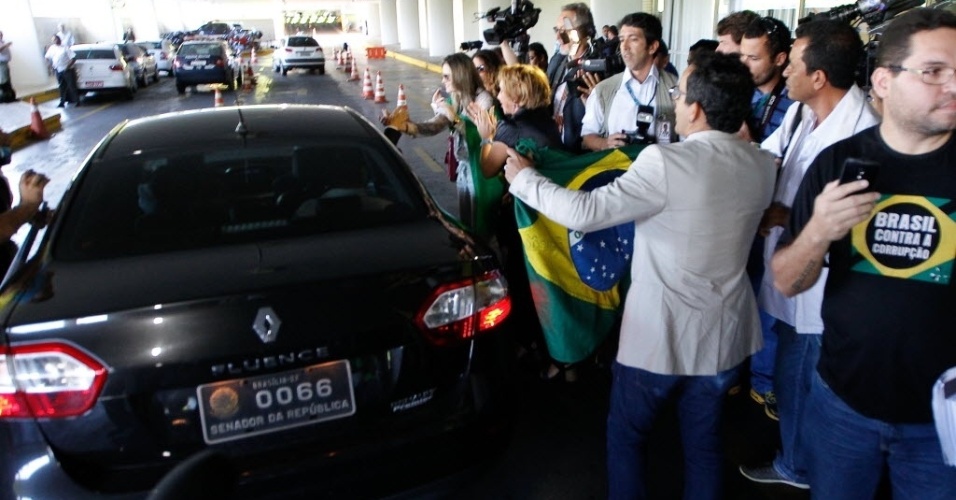3.dez.2014 - Manifestantes cercam o carro do senador José Sarney (PMDB-AP) em protesto durante votação de manobra fiscal destinada a fechar as contas do governo em 2014 no Congresso Nacional, em Brasília