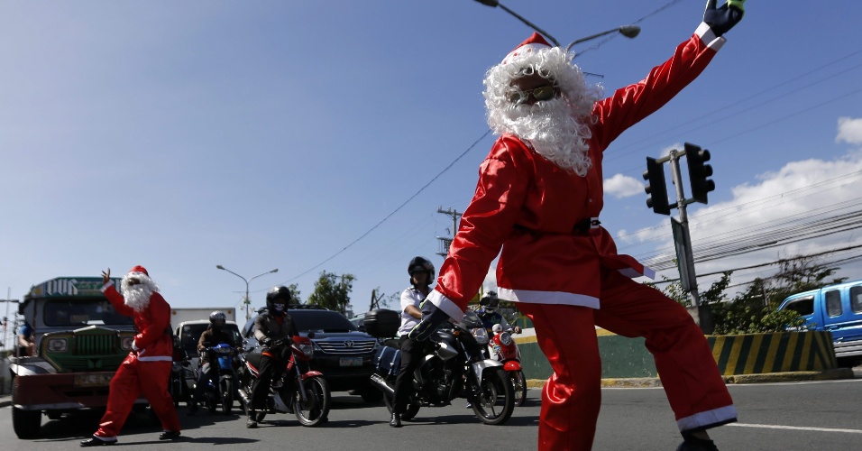3.dez.2014 - Oficiais de segurança filipinos orientam o trânsito fantasiados de Papai Noel, na cidade de Paranaque, ao sul da capital Manila. Os filipinos têm uma das celebrações de Natal mais longas do mundo - os festejos começam no mês de setembro