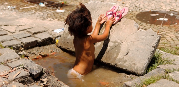 A garota Maria foi flagrada brincando com água em um bueiro no Rio de Janeiro - Marcelo Piu/Agência O Globo
