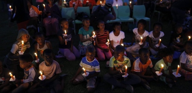 Crianças seguram velas durante um ato em memória a um ano da morte do ex-presidente da África do Sul, Nelson Madela, em Soweto, Johanesburgo - Kim Ludbrook/EFE