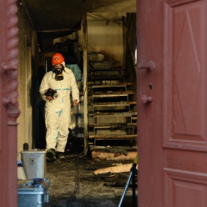 Policial investiga casa incendiada em Vorra, próximo a Nuremberg, no sul da Alemanha, no fim de 2014; local abrigava refugiados - Christof Stache/AFP