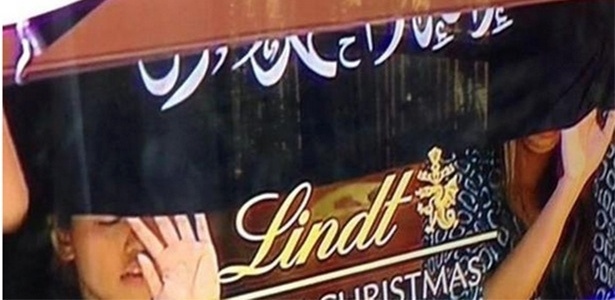 Reféns em vitrina da Lindt em Sydney (Austrália), com faixa com dizeres árabes - Reprodução/Twitter/@daiiytelegraph