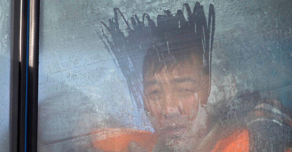 15.dez.2014 - Homem vê a corrida Master Cross 2014 através de uma janela coberta de geada em Suuj Uul, fora de Ulan Bator, na Mongólia