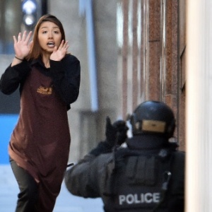 15.dez.2014 - Refém foge em direção à polícia em um café no distrito empresarial central de Sydney