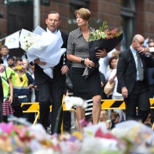 Tony Abbott e sua mulher, Margaret, deixaram flores nesta terça em memorial a vítimas do sequestro - Peter Parks/AFP