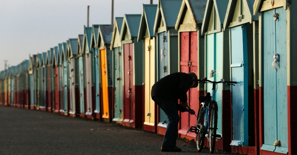 16.dez.2014 - Um homem infla o pneu da bicicleta perto de barracas de praia, em Brighton, na Inglaterra