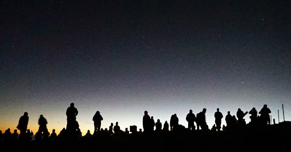 16.dez.2014 - Visitantes se reúnem para assistir ao nascer do sol sobre cume de 3.055 metros do vulcão Haleakala, na ilha havaiana de Maui, EUA