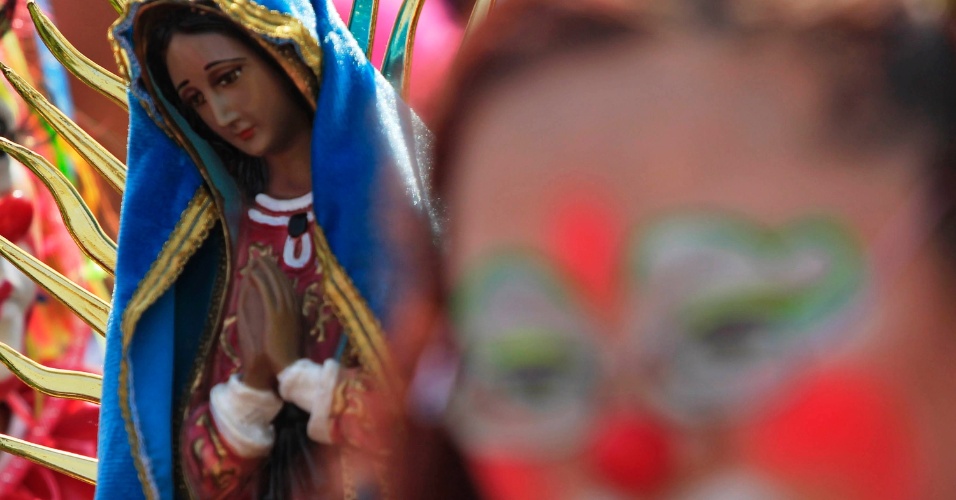 17.dez.2014 - Estatueta da Virgem de Guadalupe é vista junto a palhaços que fazem sua peregrinação anual à Basílica de Nossa Senhora de Guadalupe na Cidade do México