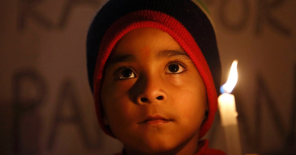 17.dez.2014 - Menino segura uma vela e reza durante vigília, em Katmandu, no Nepal, pelo massacre de crianças em uma escola no Paquistão