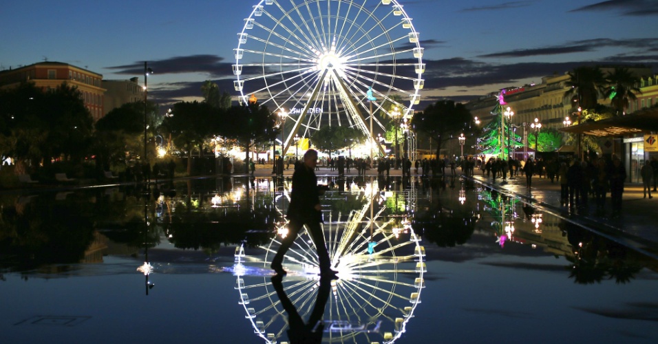19.dez.2014 - Homem caminha perto de roda gigante iluminada, no centro de Nice, na França