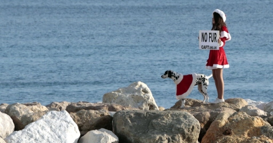 20.dez.2014 - Mamãe Noel segura cartaz durante protesto contra o comércio de pele de animais em praia de Nice, no sul da França. Ativistas fizeram um apelo aos consumidores para não comprarem peles no Natal 