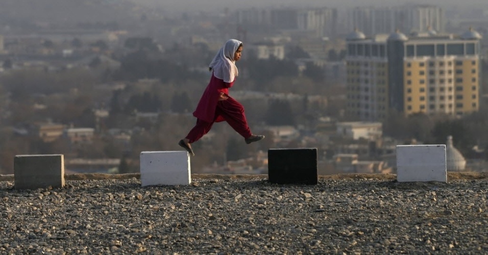 21.dez.2014 - Menina caminha sobre uma colina com vista para Cabul, no Afeganistão