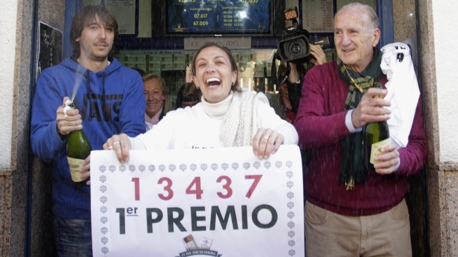 A vendedora Raquel Carrasco segura uma placa com o número vencedor da loteria de Natal espanhola de 2014, conhecida como "El Gordo", em La Eliana, perto de Valência, nesta segunda-feira (22). O montante foi dividido em milhares de prêmios - Heino Kalis/Reuters